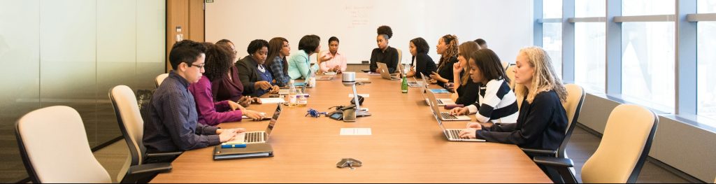 Women seated around a conference table technology-facilitated gender-based violence